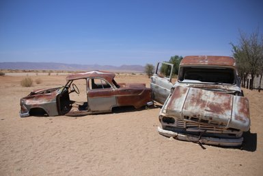 Zwei rostige Autos stehen verlassen in einer Wüste - Namibia mit Kindern