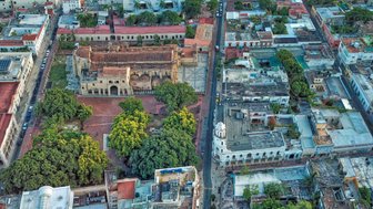 Ein Blick auf die Plaza Colón in Santo Domingo, umgeben von historischen Gebäuden und üppigem Grün.
