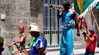 Straßenparade mit Musikern in bunten Kostümen, die Trommeln und Trompeten spielen - Kuba mit Kindern