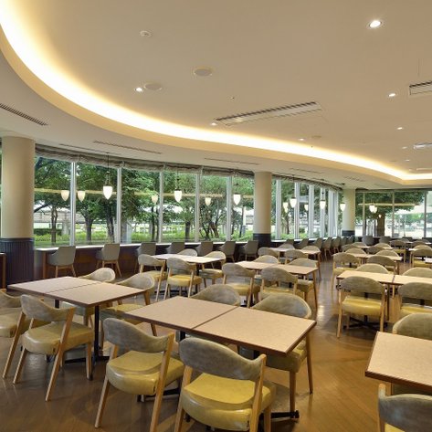 Ein modernes Restaurant mit großen Fenstern, das viel Tageslicht hereinlässt und eine einladende Atmosphäre schafft.