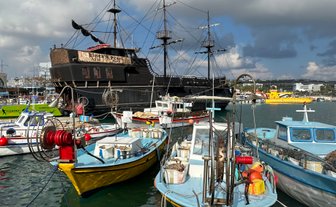 Im Hafen von Limassol liegen bunte Fischerboote vor dem beeindruckenden Piratenschiff 'Black Pearl'.