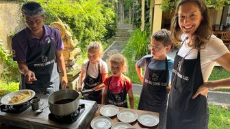 Familie bereitet gemeinsam traditionelle balinesische Gerichte zu – Bali Familienreise