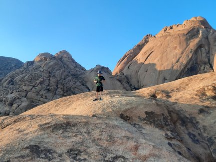 Ein Junge steht stolz auf einem Felsen - Namibia mit Kindern
