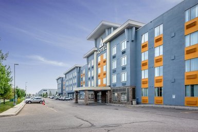 Das moderne Hotelgebäude in Calgary zeigt eine auffällige Fassade mit blauen und orangefarbenen Akzenten.