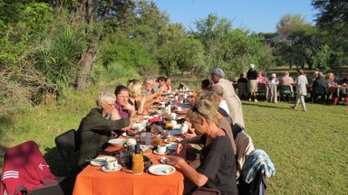 Familien aus der Reisegruppe genießen gemeinsam ein Abendessen im Makutsi Game Reserve – Südafrika Reise mit Kindern