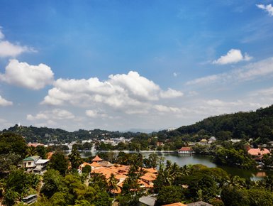 Panoramablick auf die Stadt Kandy mit grüner Landschaft und Häusern im Tal – Sri Lanka Familienreise