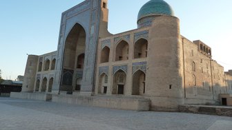 Die Miri-Arab-Madrasa in Buchara zeigt beeindruckende Architektur mit einem markanten blauen Kuppeldach und kunstvollen Verzierungen.