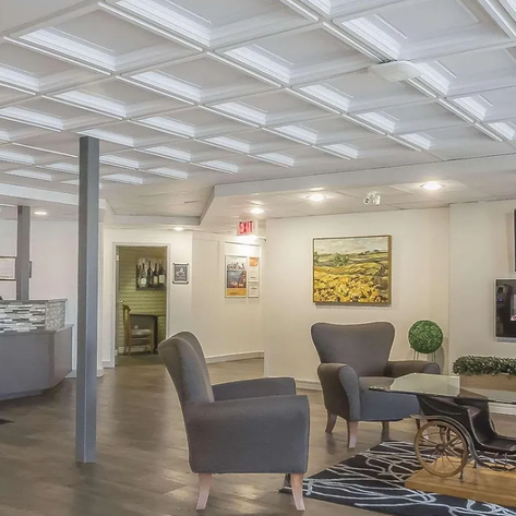 Der Empfangsbereich eines Hotels mit modernen Möbeln, einem eleganten Tisch und einer stilvollen Wanddekoration.