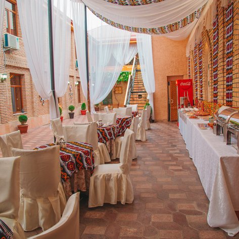 Ein eleganter Restaurantbereich mit bunten Tischdecken und weißen Vorhängen, der eine einladende Atmosphäre schafft.
