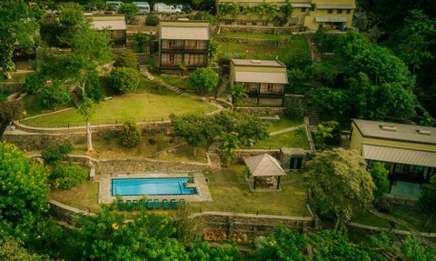 Eine malerische Aussicht auf das Melheim Resort in Haputale, umgeben von üppigem Grün und einem einladenden Pool.