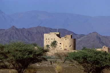 Festung von Bahla mit Bergen im Hintergrund im Oman – Oman mit Kindern