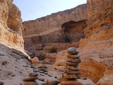 Mehrere Steine sind aufeinander gestapelt und bilden zwei Steintürme - Namibia mit Kindern