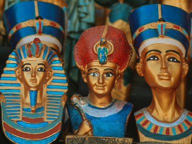 Bunte Statuetten ägyptischer Pharaonen und Göttinnen, die mit goldenen und blauen Farben verziert sind.
