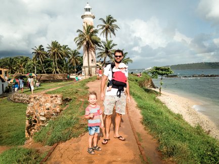 Vater mit zwei Kindern vor dem weißen Leuchtturm im Galle Fort – Sri Lanka Reise mit Kindern