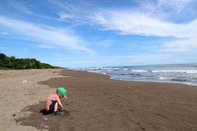 Kind am Sandstrand mit sanften Wellen im Tortuguero Nationalpark – Costa Rica Familienreise