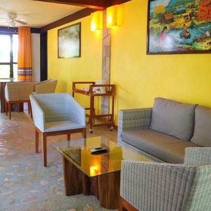 Ein einladender Lounge-Bereich mit hellen Wänden, gemütlichen Möbeln und bunten Vorhängen, ideal zum Entspannen.