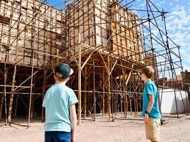 Kinder schauen neugierig auf die Filmkulissen der Atlas Film Studios in Marokko – Familienurlaub in Marokko