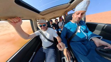 Familie mit Beduin im Geländewagen auf Wüstentour – Oman Familienreise