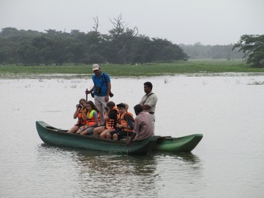 Kinder sitzen auf einem traditionellen Katamaran auf einem Fluss – Sri Lanka Reise mit Kindern