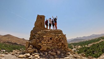 Familie steht oben auf einem Felsenhaus im Dorf Birkat Al Mauz – Oman mit Kindern