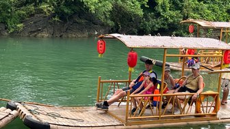 Familie gleitet entspannt auf einem traditionellen Bambusfloß über den Yulong-Fluss – China mit Kindern