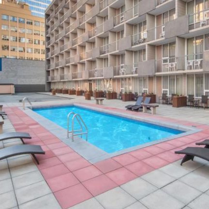 Ein einladender Poolbereich im Freien, umgeben von modernen Hotelzimmern und urbaner Architektur in Calgary.