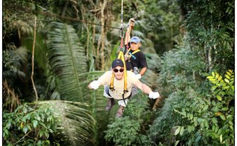 Teen fröhlich beim Ziplining durch den tropischen Wald – Mexiko Familienreise
