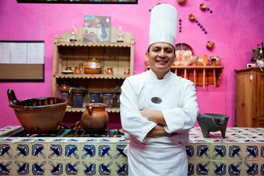 Koch in einer traditionell eingerichteten mexikanischen Küche – Mexiko Reise mit Kindern