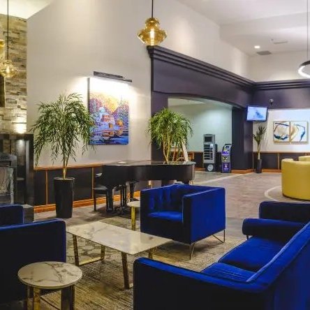 Der elegante Empfangsbereich des Hotels La Montagnais mit blauen Sofas und einem modernen Kamin strahlt Gemütlichkeit aus.