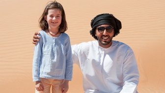 Mädchen trifft einen Beduinen in der Weite der Wahiba Sands – Oman Familienreise