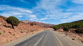 Landstraße führt durch die Landschaft mit beeindruckender Bergsicht in Marokko – Familienreise nach Marokko