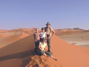 Eine Familie steht auf einer Sanddüne - Namibia mit Kindern