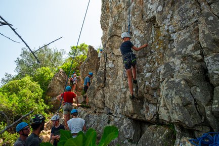 Eine Gruppe klettert einen steilen Felsen hoch