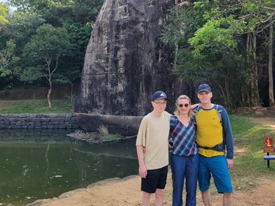 Familie steht lächelnd und posiert für ein Erinnerungsfoto – Sri Lanka Familienreise