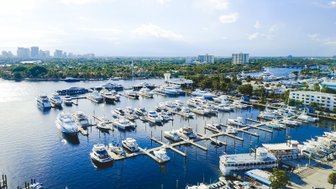 Eine Luftaufnahme eines geschäftigen Yachthafens in Fort Lauderdale, umgeben von modernen Gebäuden und üppiger Vegetation.