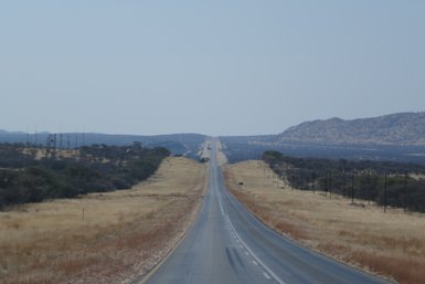 Panoramablick auf eine weite Straße - Namibia mit Jugendlichen