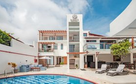 Ein modernes Boutique-Hotel mit einem einladenden Pool und stilvollen Liegen, umgeben von einer hellen, freundlichen Atmosphäre.