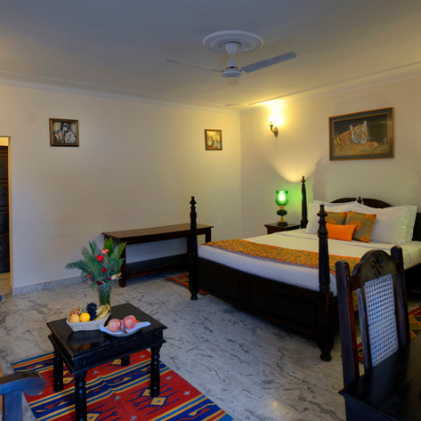 Ein gemütliches Zimmer mit einem großen Bett, bunten Kissen und einer warmen Atmosphäre, ideal für Entspannung.