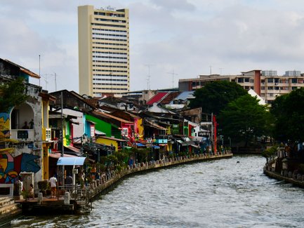 Farbige Häuserfronten spiegeln sich im ruhigen Fluss von Malakka – Malaysia & Borneo Familienreise