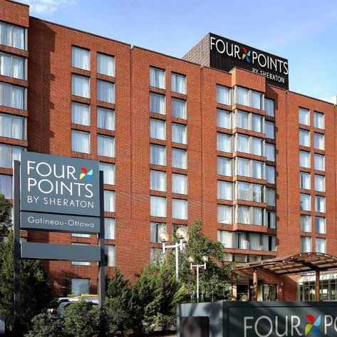 Das Four Points by Sheraton Hotel in Gatineau-Ottawa zeigt eine moderne, rote Backsteinfassade mit großen Fenstern.