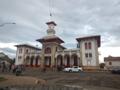 Das historische Gebäude in Antsirabe zeigt eine beeindruckende Architektur mit roten Fenstern und einem markanten Turm.