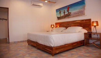 Ein helles, modernes Schlafzimmer mit einem großen Holzbett und zwei Nachttischen, beleuchtet von warmen Lampen.