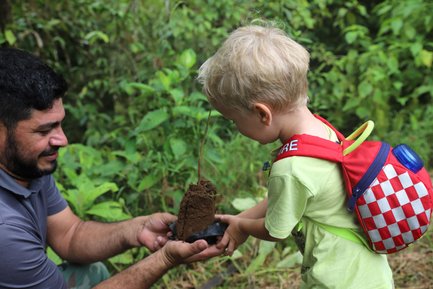 Kleinkind und Guide beim Baumpflanzen in La Tigra – Costa Rica Familienreise