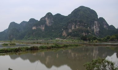 Junges Kind fährt Fahrrad entlang der Küste der Halong-Bucht – Vietnam Familienreise
