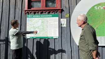 Eine Person zeigt auf eine Karte des Soomaa Nationalparks, während eine andere Person aufmerksam zuhört.