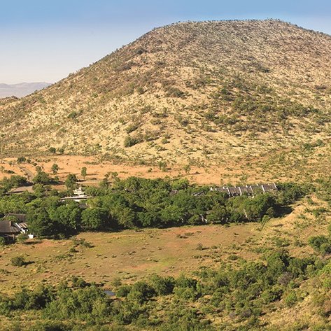 Eine weite Landschaft mit sanften Hügeln und üppigem Grün, das die Umgebung des Kwa Maritane Bush Lodge umgibt.