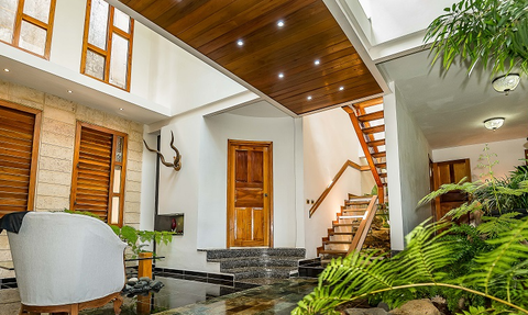 Ein einladender Lobbybereich mit Holzdecke, hellen Fenstern und einer Treppe, die ins Obergeschoss führt.