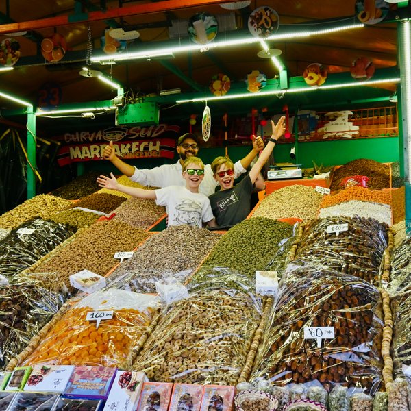 Zwei Kinder entdecken bunte Gewürze an einem traditionellen Marktstand in Marrakesch – Marokko Familienreise