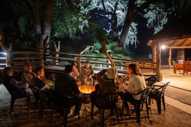 Familie sitzt gemütlich am Lagerfeuer im Makutsi Game Reserve – Südafrika Reise mit Kindern