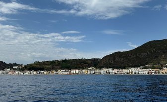 Eine malerische Küstenlinie mit bunten Häusern, die sich entlang des Wassers erstrecken, unter einem klaren blauen Himmel.